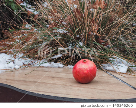 Ripe pomegranate fruit on wooden surface during cold winter Ripe pomegranate fruit on wooden surface during cold winter 140346260