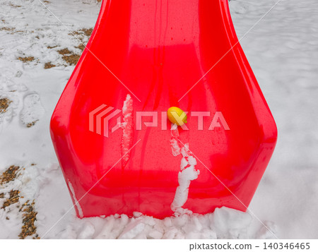 Lemon on red slide in winter playground snow Lemon on red slide in winter playground snow 140346465