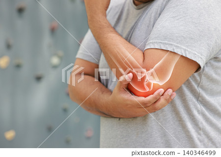 Close up of a man suffering from elbow joint pain with glowing bone anatomy graphic overlay after rock climbing exercise. Sports injury and medical healthcare concept. Close up of a man suffering from elbow joint pain with glowing bone anatomy graphic overlay after rock climbing exercise. Sports injury and medical healthcare concept. 140346499