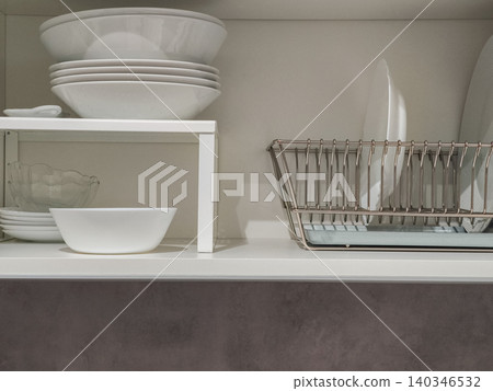 Organizing kitchen dishes in modern cabinet 140346532