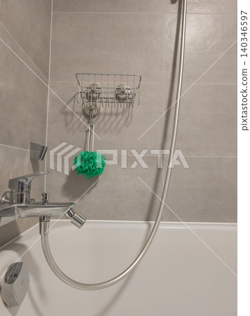 Modern bathroom showing bathtub shower faucet and bath sponge Modern bathroom showing bathtub shower faucet and bath sponge 140346597