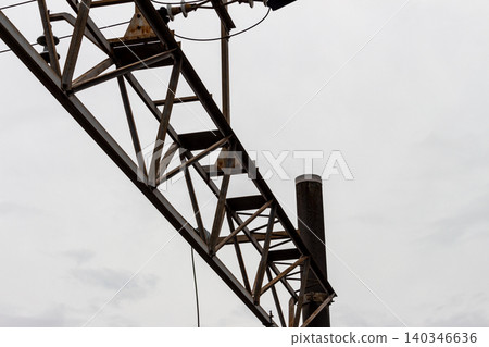 A close-up view of overhead line poles and truss beams (railway infrastructure) A close-up view of overhead line poles and truss beams (railway infrastructure) 140346636