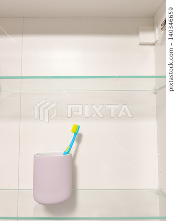 Toothbrush in bathroom cabinet on glass shelf Toothbrush in bathroom cabinet on glass shelf 140346659