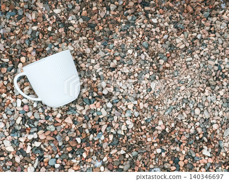 White mug resting on natural gravel surface White mug resting on natural gravel surface 140346697