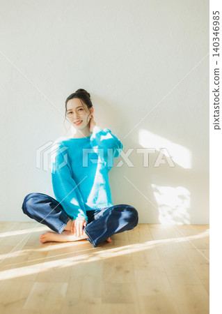 一位年輕女子在地板上放鬆休息。 140346985