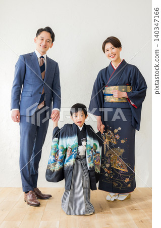 A boy wearing a hakama and his parents A boy wearing a hakama and his parents 140347166