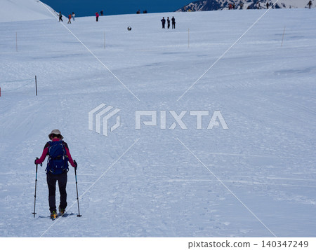 Snowy scenery and hikers at the summit of Murodo Mountain on the Tateyama Kurobe Alpine Route, a popular tourist spot. Snowy scenery and hikers at the summit of Murodo Mountain on the Tateyama Kurobe Alpine Route, a popular tourist spot. 140347249