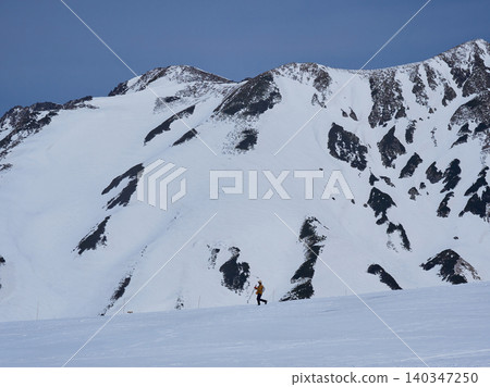 Snowy scenery and hikers at the summit of Murodo Mountain on the Tateyama Kurobe Alpine Route, a popular tourist spot. Snowy scenery and hikers at the summit of Murodo Mountain on the Tateyama Kurobe Alpine Route, a popular tourist spot. 140347250