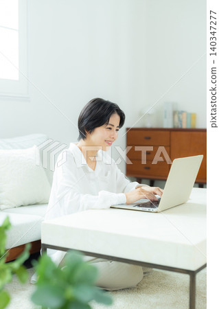 A woman watching a computer at home A woman watching a computer at home 140347277