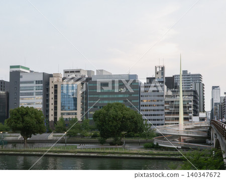 The office buildings lining the Okawa River and the evening view of the Nakanoshima pedestrian bridge. 140347672