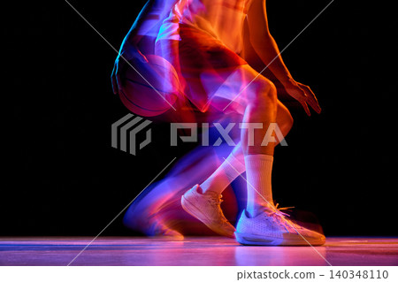 Close basketball dribble detail with neon motion blur on black background. 140348110