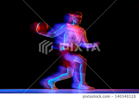Basketball player running with ball through neon blur on black background. Basketball player running with ball through neon blur on black background. 140348128