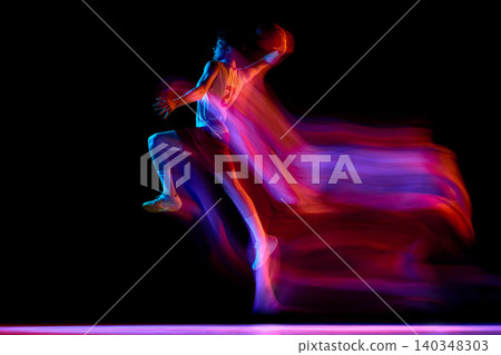 Basketball player in colorful motion blur with wide stance on black background. Basketball player in colorful motion blur with wide stance on black background. 140348303
