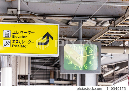 Close-up of the information sign and clock installed on the train station platform. Close-up of the information sign and clock installed on the train station platform. 140349153