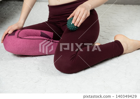 Self-massage technique with green massage ball on leg after workout Self-massage technique with green massage ball on leg after workout 140349429