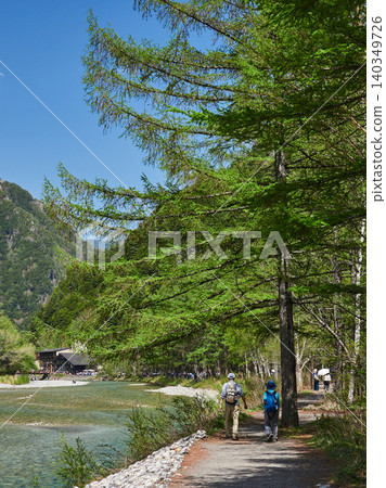 The scenery of the lush green forests of Kamikochi, a popular spring tourist spot, and the sight of tourists walking along the walking trails. The scenery of the lush green forests of Kamikochi, a popular spring tourist spot, and the sight of tourists walking along the walking trails. 140349726