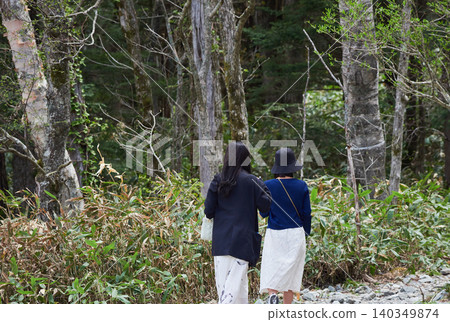 A female tourist strolling through the forests of Kamikochi, a popular tourist spot in early summer. A female tourist strolling through the forests of Kamikochi, a popular tourist spot in early summer. 140349874