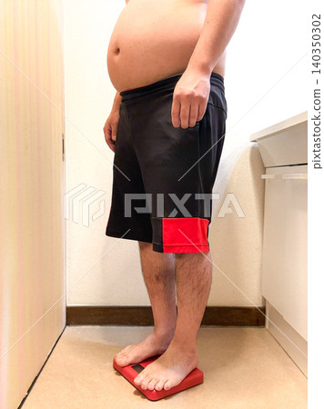 一位中年肥胖男子站上了體重計。 一位中年肥胖男子站上了體重計。 140350302