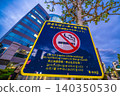 Sign in front of Kayabacho Station: No smoking while walking or littering in Tokyo's urban landscape. 140350530