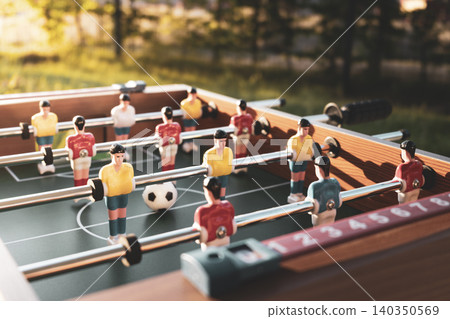 Foosball table with red white and yellow blue plastic soccer players, expressing connecting to worldwide football Foosball table with red white and yellow blue plastic soccer players, expressing connecting to worldwide football 140350569