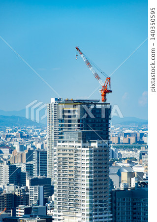 A construction site for a high-rise apartment building and a tower crane. A construction site for a high-rise apartment building and a tower crane. 140350595
