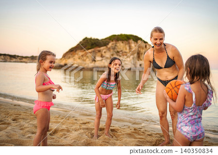 Happy family playing with a ball on a beach in Greece 140350834