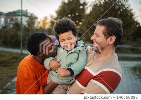 Happy multicultural family playing outdoors with child Happy multicultural family playing outdoors with child 140350888