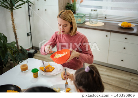 Mother and child enjoying healthy meal together in kitchen Mother and child enjoying healthy meal together in kitchen 140350909