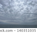 A landscape of cloudy skies and a calm sea stretching to the horizon. 140351035