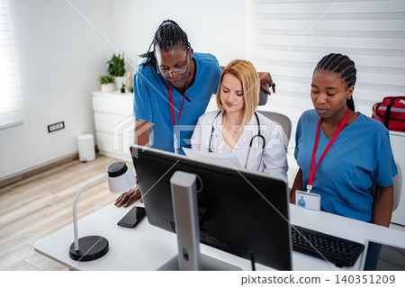 Medical team collaborating on computer healthcare information Medical team collaborating on computer healthcare information 140351209