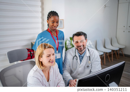 Medical team collaborating on computer in clinic 140351211