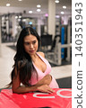 Pensive Asian woman in pink activewear looking away near plyo box in gym 140351943