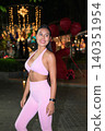 Smiling Asian woman in pink sportswear at night street event 140351954