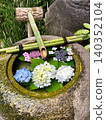 A water basin with a few brightly colored hydrangeas floating in it. 140352104