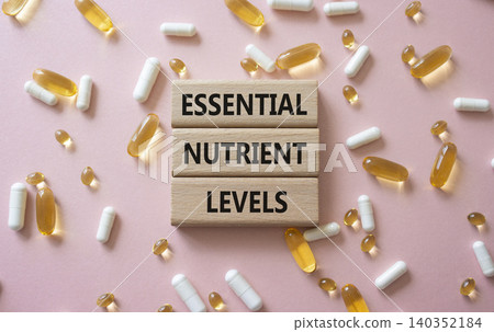 Essential nutrient levels symbol. Concept words Essential nutrient levels on wooden blocks. Beautiful pink background with pills. Healthcare and Essential nutrient levels concept. Copy space. Essential nutrient levels symbol. Concept words Essential nutrient levels on wooden blocks. Beautiful pink background with pills. Healthcare and Essential nutrient levels concept. Copy space. 140352184