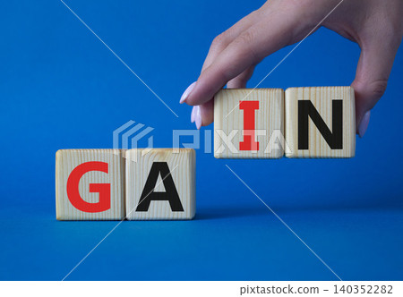 Gain symbol. Concept word Gain on wooden cubes. Businessman hand. Beautiful blue background. Business and Gain concept. Copy space. 140352282