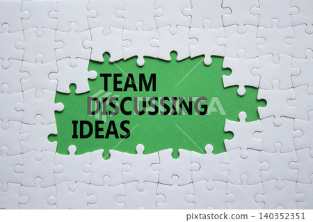 Team Discussing Ideas symbol. White puzzle with words Team Discussing Ideas. Beautiful green background. Business concept. Copy space. Team Discussing Ideas symbol. White puzzle with words Team Discussing Ideas. Beautiful green background. Business concept. Copy space. 140352351