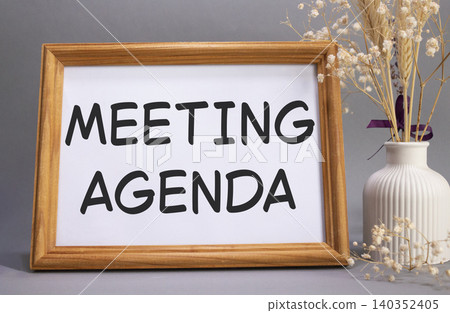 Meeting agenda symbol. Concept words Meeting agenda on beautiful wooden picture frame. Beautiful grey background with flower vase. Business and Meeting agenda concept. Copy space. Meeting agenda symbol. Concept words Meeting agenda on beautiful wooden picture frame. Beautiful grey background with flower vase. Business and Meeting agenda concept. Copy space. 140352405