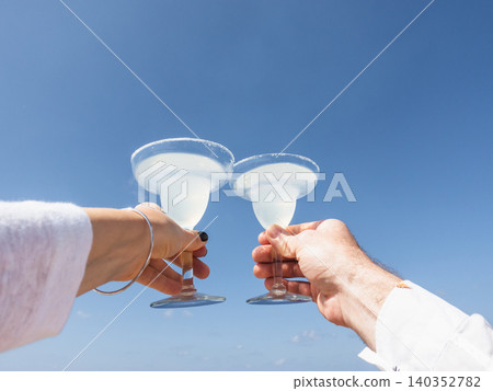 Two hands holding glasses of drink Two hands holding glasses of drink 140352782