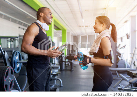 Young black talking and smiling after workout session in modern gym Young black talking and smiling after workout session in modern gym 140352923