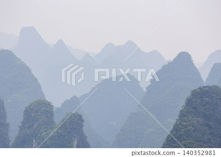 Misty peaks rise softly in layered silence Misty peaks rise softly in layered silence 140352981