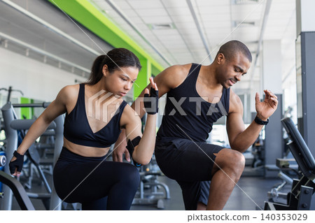 Young black fitness performing dynamic warm up exercises in modern gym Young black fitness performing dynamic warm up exercises in modern gym 140353029