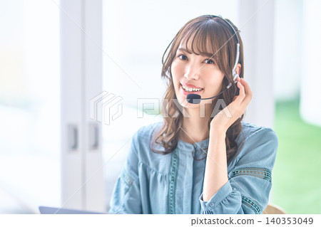 A smiling female operator speaking into a headset while looking directly at the camera. A smiling female operator speaking into a headset while looking directly at the camera. 140353049