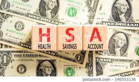HSA health saving account symbol. Concept words HSA health saving account on beautiful wooden blocks. Beautiful dollar bills background. Medical HSA health saving account concept. Copy space. HSA health saving account symbol. Concept words HSA health saving account on beautiful wooden blocks. Beautiful dollar bills background. Medical HSA health saving account concept. Copy space. 140353136