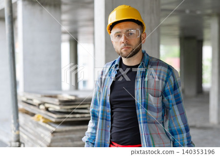 Construction worker carrying toolboxes walking on site Construction worker carrying toolboxes walking on site 140353196