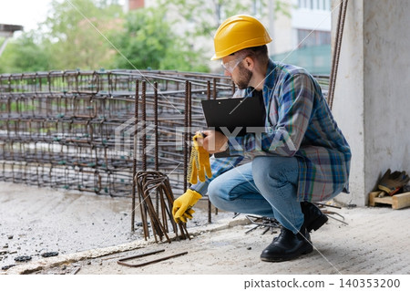 Construction engineer inspecting rebar at building site Construction engineer inspecting rebar at building site 140353200