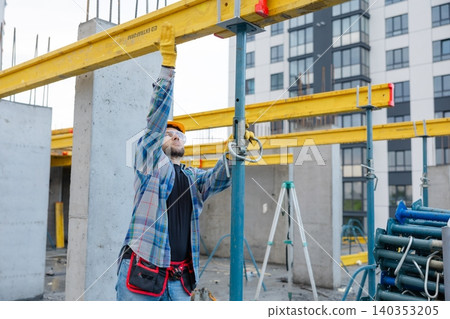 Construction worker adjusting formwork system on building site Construction worker adjusting formwork system on building site 140353205