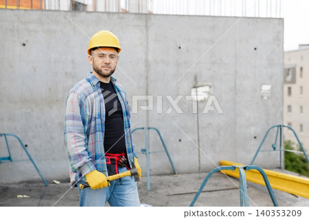 Worker wearing hard hat and safety glasses on building site Worker wearing hard hat and safety glasses on building site 140353209