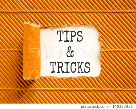 Tips and tricks words symbol. Concept words Tips and tricks on beautiful white paper. Beautiful brown background. Business tips and tricks motivational support concept. Copy space. Tips and tricks words symbol. Concept words Tips and tricks on beautiful white paper. Beautiful brown background. Business tips and tricks motivational support concept. Copy space. 140353456