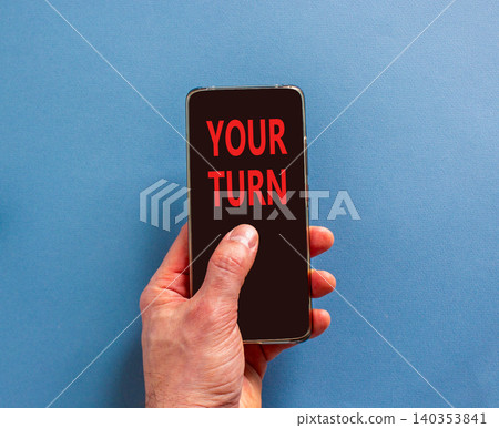Your turn words symbol. Concept words Your turn on beautiful black mobile phone screen. Beautiful blue background. Businessman hand. Business your turn motivational support concept. Copy space. Your turn words symbol. Concept words Your turn on beautiful black mobile phone screen. Beautiful blue background. Businessman hand. Business your turn motivational support concept. Copy space. 140353841